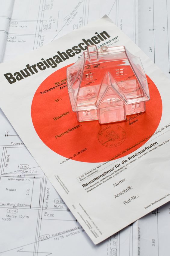 Kleines Plexiglashäuschen auf einem Baufreigabeschein-Dokument