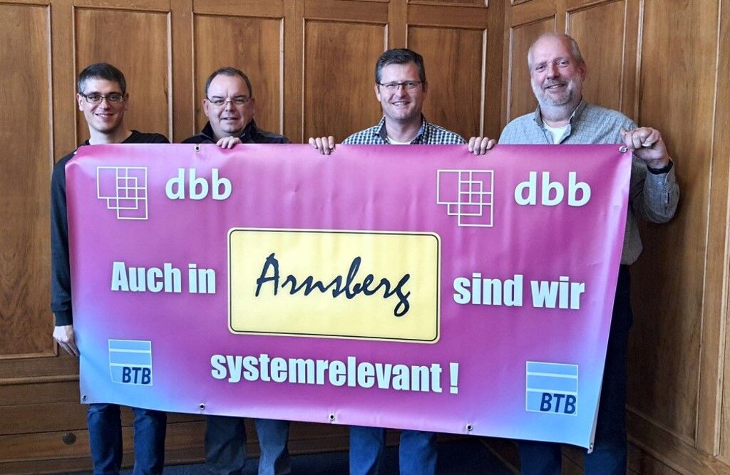 4 Männer halten ein Plakat mit er Aufschrift: Auch in Arnsberg sind wir systemrelevant!